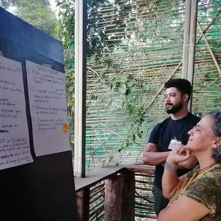 Coordenadora Rita Mesquita e Membro da Equipe Vínicius Peripato observando os encaminhamentos finais listados na oficina de fechamento do projeto Regenera. Abril de 2023, Pousada Bem Ecológico, Planaltina-DF.